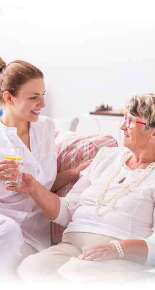 nurse talking to an elderly woman in bed